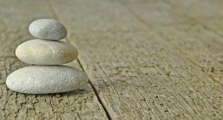 A small pile of stones on a wooden background with copy space