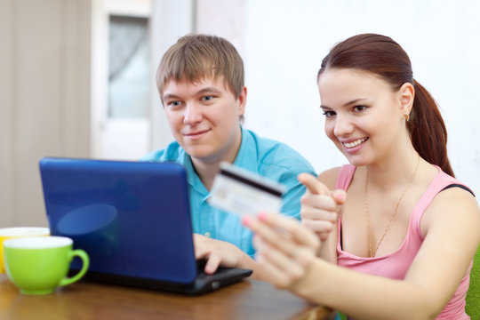 couple buying online with credit card at home