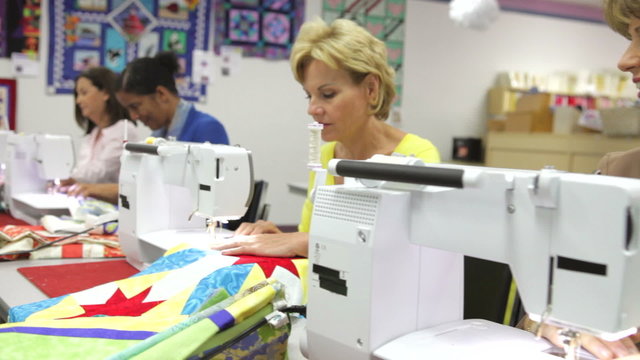 Group Of Women Using Electric Machines In Sewing Class