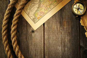 Antique compass and rope over old map