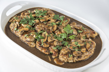 Platter of Chicken Marsala on a white background