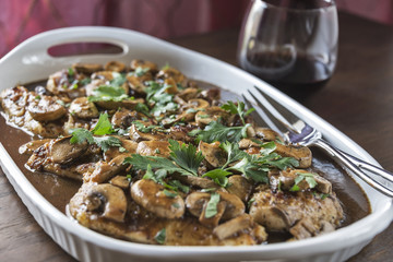 Platter of Chicken Marsala with glass of wine