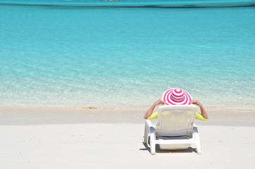 Girl in a striped hat on the beach of Exuma, Bahamas