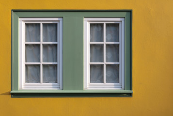 Fototapeta na wymiar Window on yellow wall of the house.