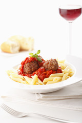 Italian meatballs with penne pasta in tomato sauce