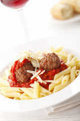 Italian meatballs with penne pasta in tomato sauce
