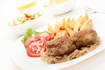 Meatballs with stewed onion and fried potato wedges