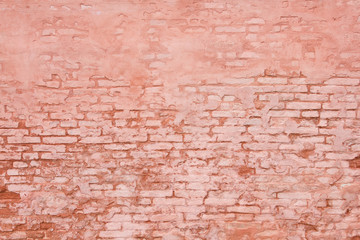 Rustic brick wall partially covered with  plaster