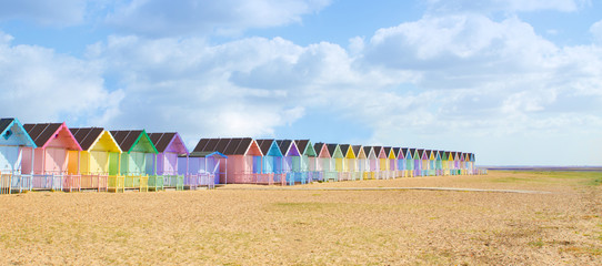 Traditional British beach huts on a bright sunny day