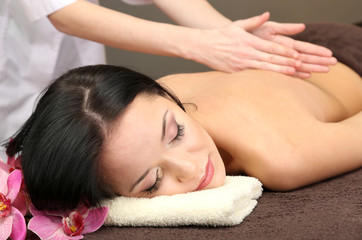 Fototapeta na wymiar Beautiful young woman in spa salon getting massage with spa
