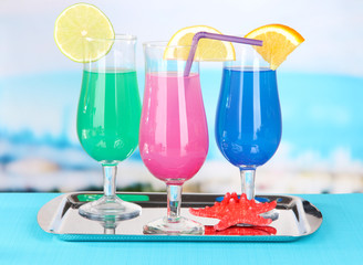 Glasses of cocktails on table near pool