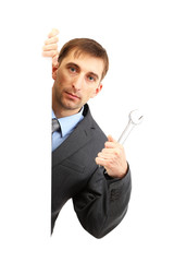 Young businessman with wrench isolated on white.