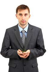 Young businessman with coins and plant isolated on white.