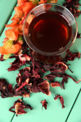 Herbal tea in glass cup, on color wooden background
