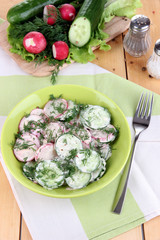 Vitamin vegetable salad in bowl on wooden table close-up