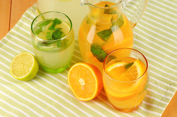 Orange and lemon lemonade in pitchers and glasses
