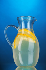 Lemonade in pitcher on blue background