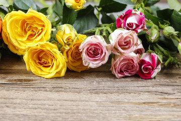 Wooden surface with copy space decorated with colorful roses