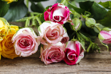 Wooden surface with copy space decorated with colorful roses