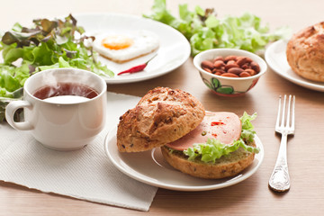 breakfast with hamburger, tea, egg and green salad