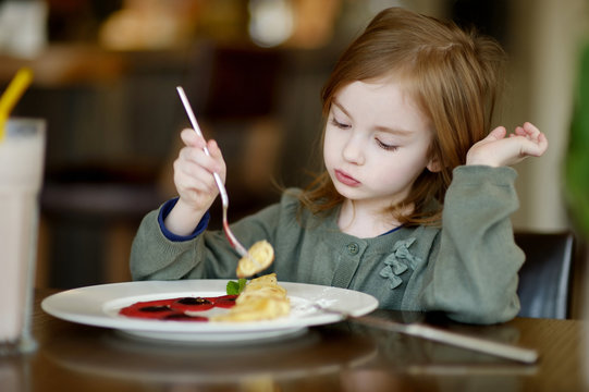 Cute Little Girl Eating Pancakes