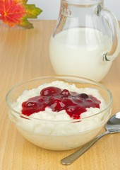 A bowl of milk rice with red berry sauce topping