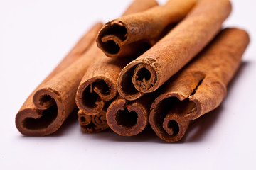 cinnamon sticks stacked on white background