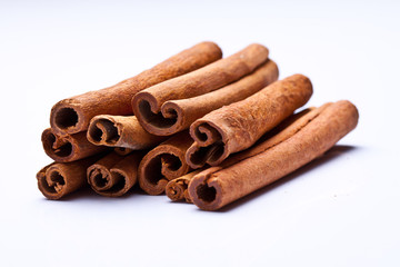 cinnamon sticks stacked on white background