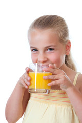 little girl drinking a glass of orange juice