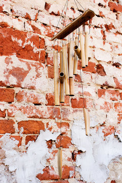 Bamboo wind chimes on the brick wall background