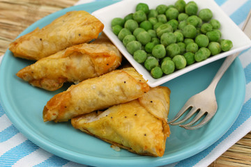 Vegetarian samosas and green peas, close up