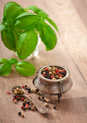mixture of pepper peas in an old bowl and basil leaves