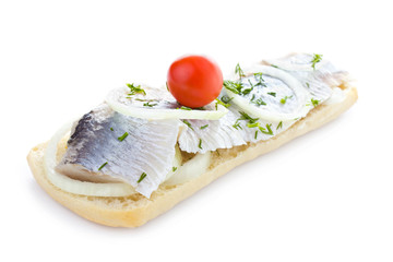 Sandwich with herring, onions, cherry tomato and herbs, isolated