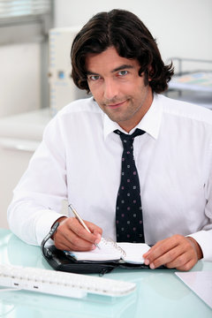 Businessman writing in a diary