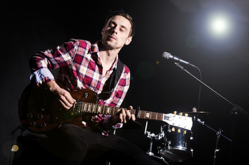 Obraz premium Man playing guitar during concert