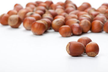 Unbroken hazelnuts on white surface