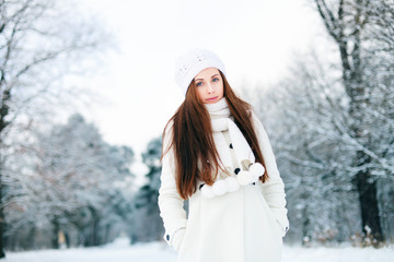 Portrait of a pretty happy girl in the winter forest