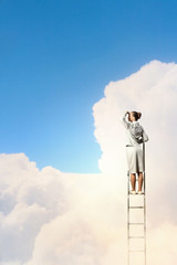 Businesswoman standing on ladder