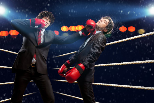 Two young businessman boxing