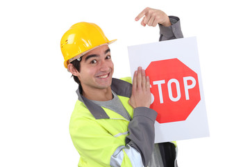 Traffic worker pointing to stop sign