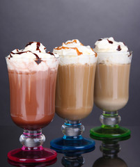 Layered coffee in glass on table on grey background