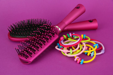 Scrunchies, hairbrush  and  hair - clip   on a pink background