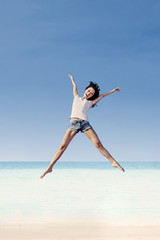 Girl jumping under blue sky