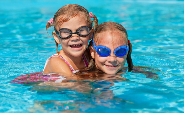 two happy little girls  in the pool