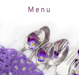 menu with silverware and fresh, wild violets