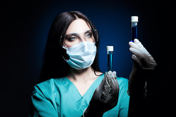 scientist holding two tubes in dark blue light