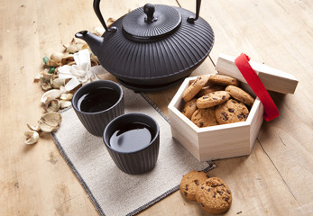 beautiful teapot with chocolate biscuits on wooden table, delici