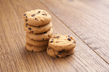 stack of chocolate biscuits with chocolate on wooden table