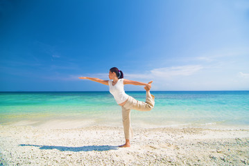 beach yoga performed by a matured asian female