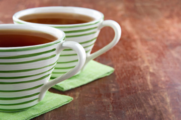 Two cups of tea on wooden background